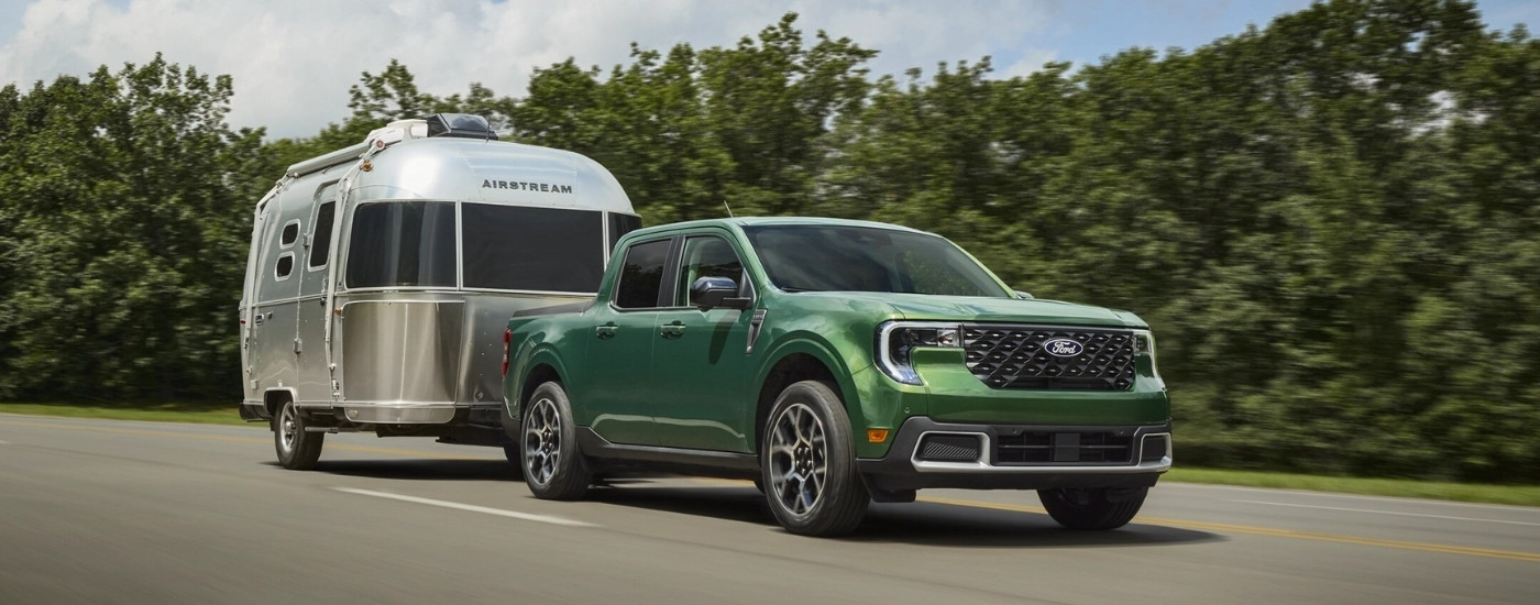 A green 2025 Ford Maverick towing an Airstream trailer
